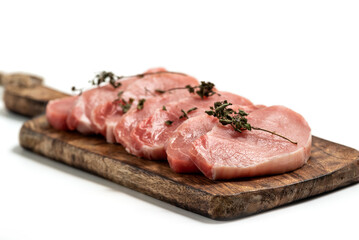 Raw pork sliced meat on wooden board on white background with dry basil leaves and spice. fresh raw beef lamb isolated on white. Heap of raw steaks
