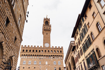 The famous Palazzo Vecchio in Florence, a wide-angle shot, framed by houses from the Piazza...