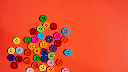 Many multi-colored buttons on an orange background.