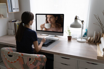 Rear view young woman professional photographer sitting at desk, working use digital graphic tablet and drawing pen. Retoucher workflow, modern tech, computer, photo editor application usage concept