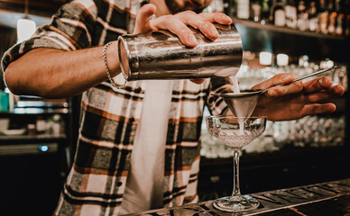 man hand bartender making cocktail in glass on the bar counter