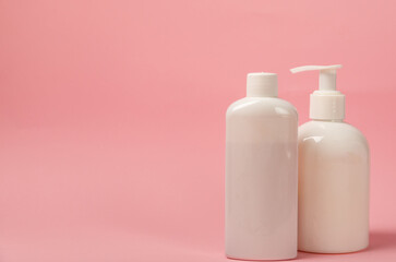 White bottles of cosmetic tonic and rinse gel on a pink background with shadow. foreground. Lotion, balm, gel, MOCKUP model from other manufacturers. pure beauty concept.