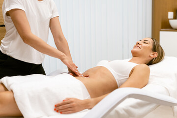 Fototapeta na wymiar Middle-aged woman having a belly massage in a beauty salon.