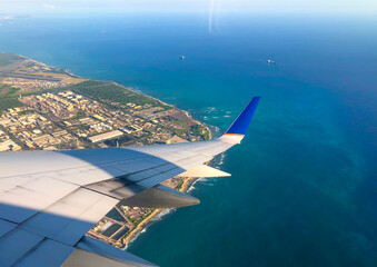 Obraz premium Sky and city view from airplane window. Aerial view of pacific ocean in hawaii