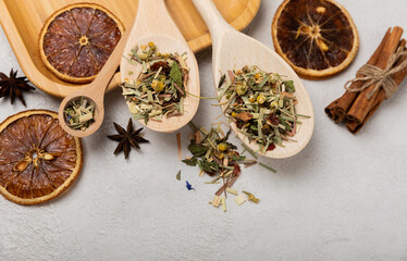 Wooden spoons with herbal tea leaves on a light background. Top view. Detox and immunity tea....