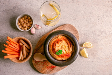 Homemade hummus with carrot sticks, with olive oil, paprika, lemon