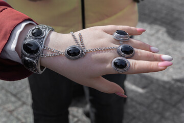 Girl's hand demonstrates jewelry made of silver and stones in a traditional Asian style.. Handmade