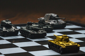 Toy tanks on a chessboard. The concept of military strategy.