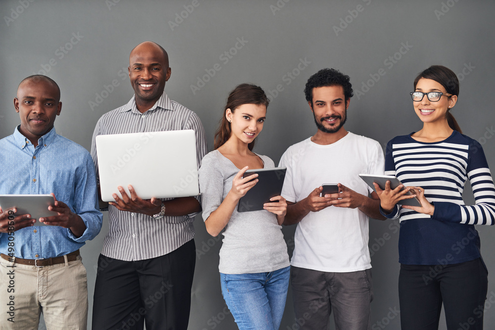 Poster theres a gadget for all your needs. studio shot of businesspeople using wireless technology against 