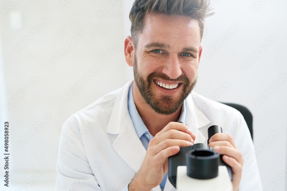 Poster Some would call him a visionary scientist. Portrait of a male scientist using a microscope in a lab.