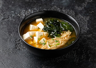 Rich miso soup with enoki mushrooms, wakame seaweed and tofu, vegetarian, vegan Asian food.