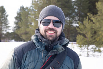 Fototapeta na wymiar Portrait of a man, a tourist in a winter forest. Outdoor recreation.