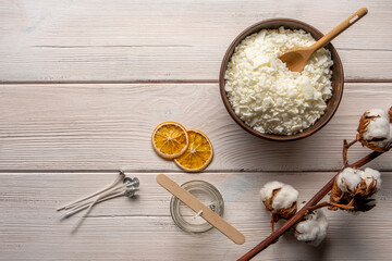 Set for crafting candle on wooden background. Eco soy wax on white table. DIY candle. Hobby concept.