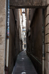 Fototapeta na wymiar BORDEAUX, FRANCE - FEBRUARY 19, 2022: Facade of medieval buildings in a dark street, narrow, in city center of Bordeaux, France. These buildings are typical of the Southwestern French architecture