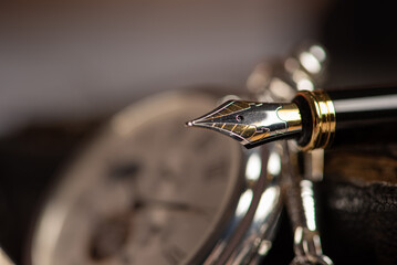 Fountain pen, beautiful fountain pen in an environment with an old clock, old book, ink among others, selective focus.