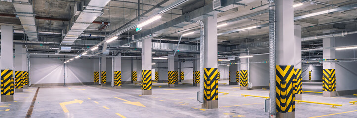 Empty shopping mall underground parking lot or garage interior with concrete stripe painted columns - obrazy, fototapety, plakaty