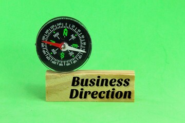 compass and wooden board with the word business direction. business strategy