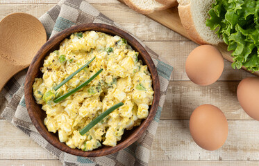 Bowl of egg salad on a wooden table
