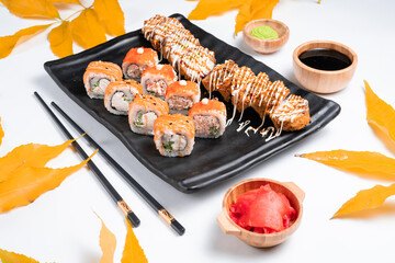 Japanese cuisine and autumn, leaves. Sushi set of nigiri and maki rolls served. Top view