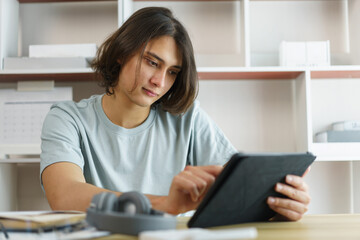 Distance education concept, Teen boy checking schedule class and studying online on tablet at home
