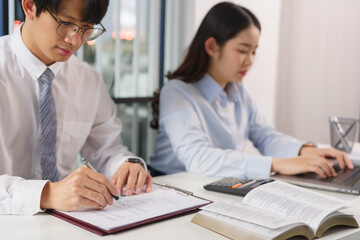 Business concept, Two business colleague checking financial data and typing report on laptop