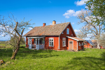 Fototapeta na wymiar Idyllic red cottage a beautiful spring day