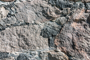 Fragment of a stone wall from old boulders. Texture from old cobblestone. Background. Close-up.