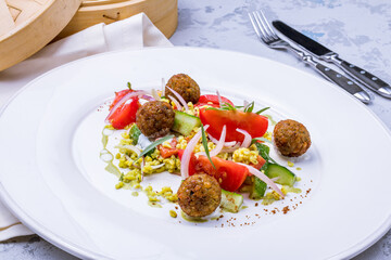 falafel balls in the dish with vegetables