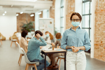 Young woman in the face mask posing in the office
