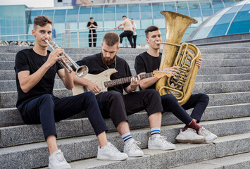 Young street music band play a lot of musical instruments