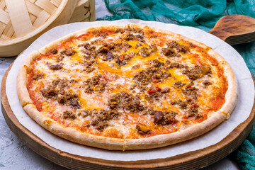 Mexican pizza with meat and cheese on the board on grey table - 498075584