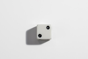 Single white dice with a two on a white background. Win or lose. Catch your luck. Gambling equipment.