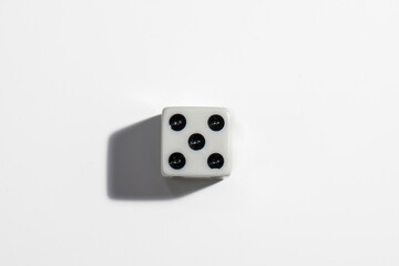Single white dice with a five on a white background. Win or lose. Catch your luck. Gambling equipment.