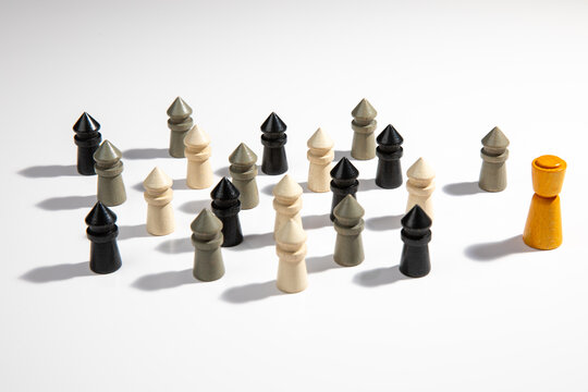 Diversity & Leadship - A group of multicolor wooden pawns for board games arranged in a group on a white background.
