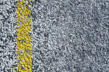 Asphalt texture with yellow markings, close-up