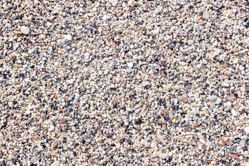 Marine small pebbles background, texture of sea sand, close-up.