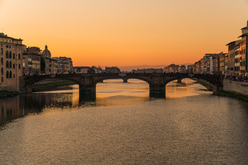 view of a bridge in Florence, Italy and sunset over the Arno river 