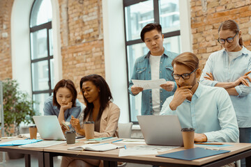 Innovative business team using laptop to brainstorm in office
