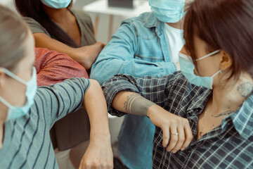 Students wearing face mask doing new social distancing greet with elbows