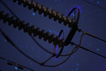 Corona discharge on high power transmission line on a night sky background - obrazy, fototapety, plakaty