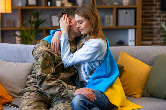Soldier surprise his wife at home. Young soldier hugging wife.
