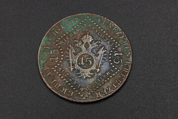 Old Austrian copper coin on black background