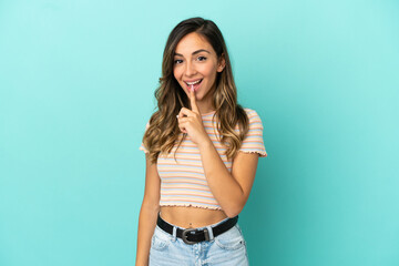 Young woman over isolated blue background showing a sign of silence gesture putting finger in mouth