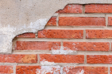Old red brick wall that gets wet. an old brick and a piece of plaster destroyed by moisture. invoice. background. place for text.