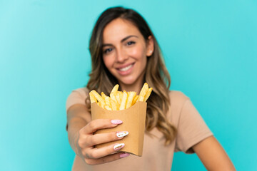 Young woman holding fried chips over isolated background