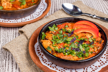 Chakhokhbili with chicken and fried vegetables, Georgian cuisine on old wooden table