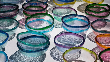 Colorful glass bowl on a white surface creating an abstract background. 
