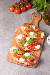 Tomato, basil and cheese fresh made caprese bruschetta. Italian tapas, antipasti with vegetables, herbs and oil on grilled ciabatta and baguette bread. Sandwich.
