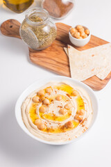Hummus in a plate with chickpeas, smoked paprika, olive oil and pita. Vegetarian food.