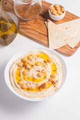 Hummus in a plate with chickpeas, smoked paprika, olive oil and pita. Vegetarian food.